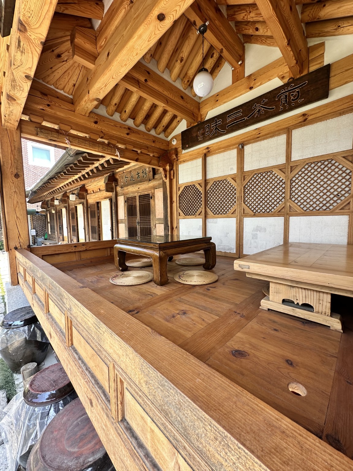 Exposed timber beams, lattice doors, low tables and floor cushions in a traditional Seoul interior