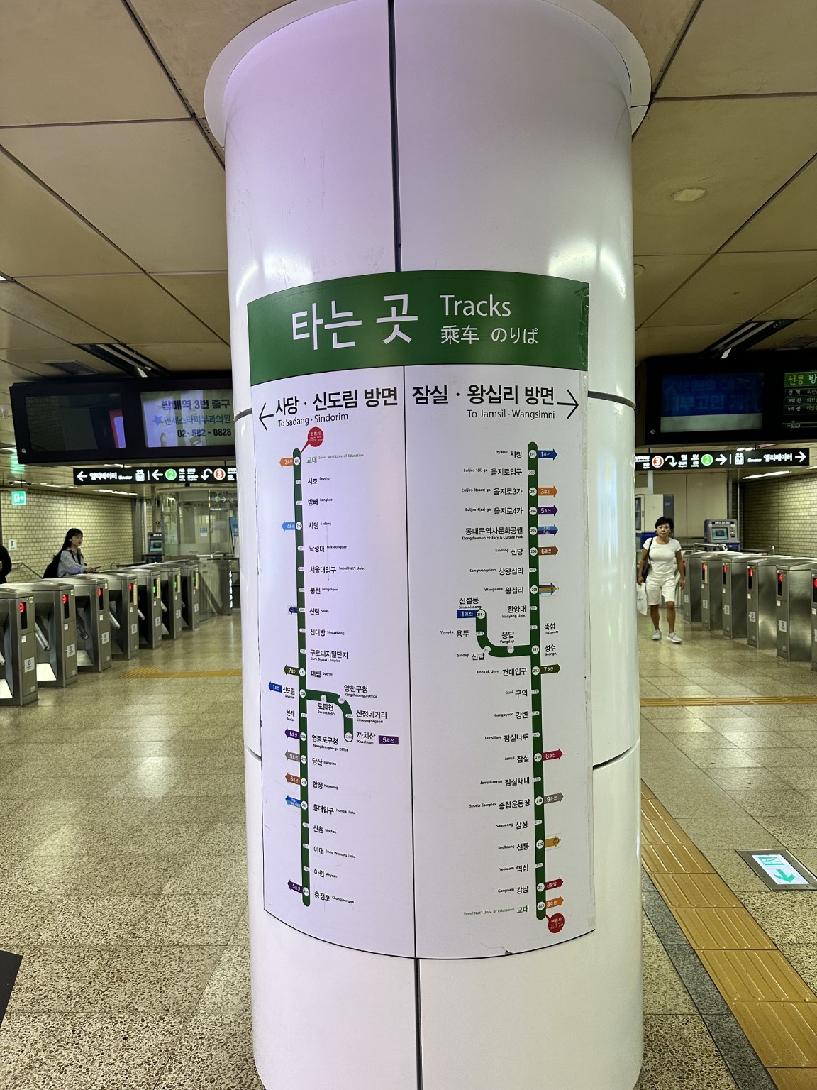 A subway route map and platform directions on a station pillar